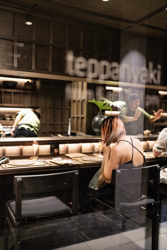 Teppanyaki restaurant through glass with moody lighting